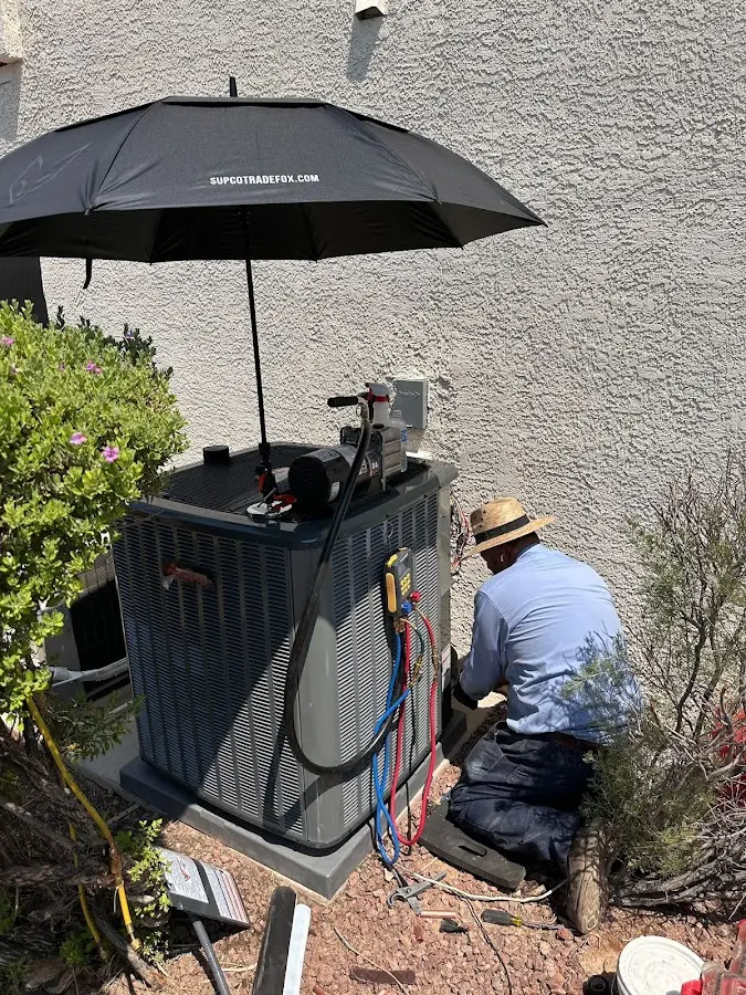 HVAC technician performing outdoor AC maintenance in Avondale