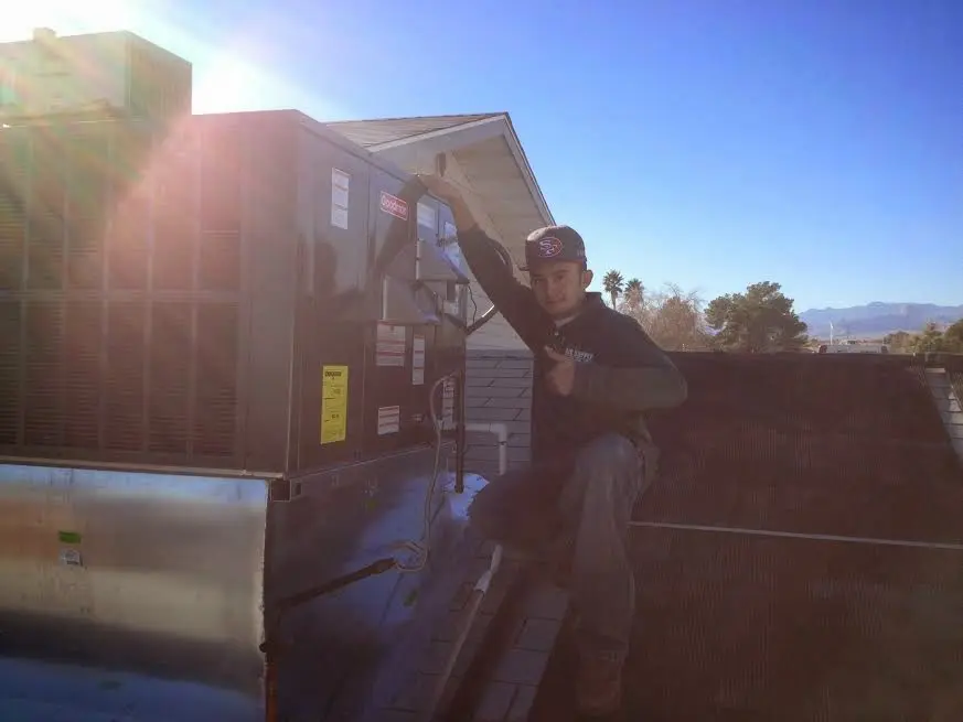 HVAC technician performing Air Duct Cleaning on a rooftop unit in Avondale